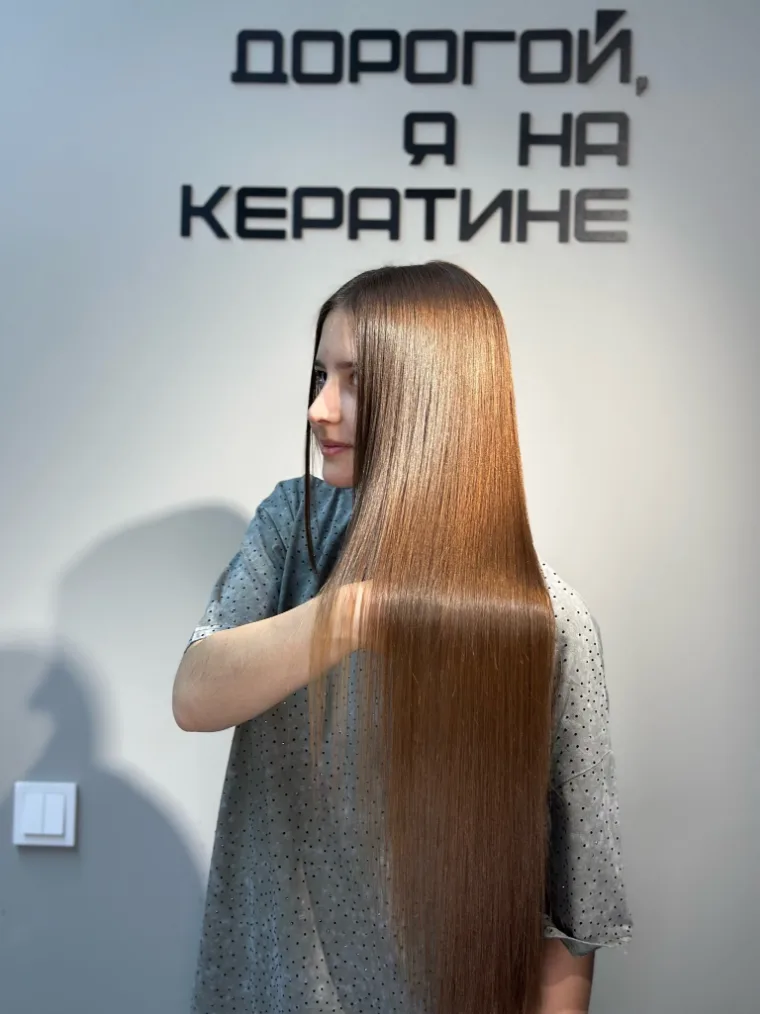 Гостья показывает гладкую прядь после процедуры
